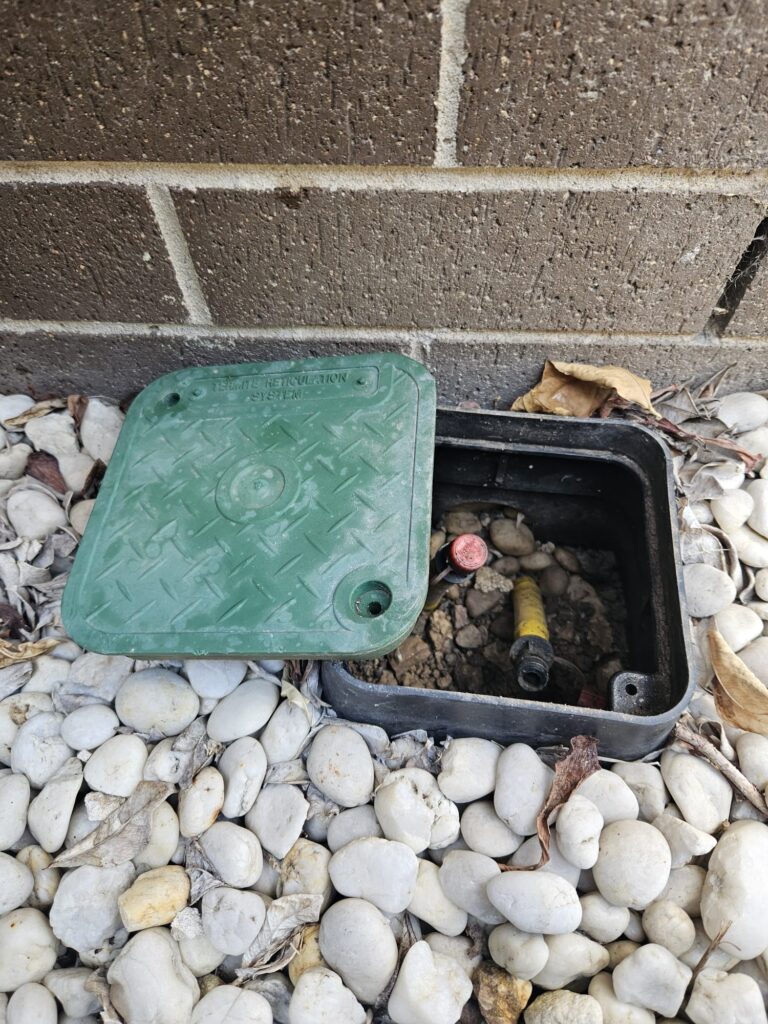 Open termite reticulation utility box in Sydney near brick wall